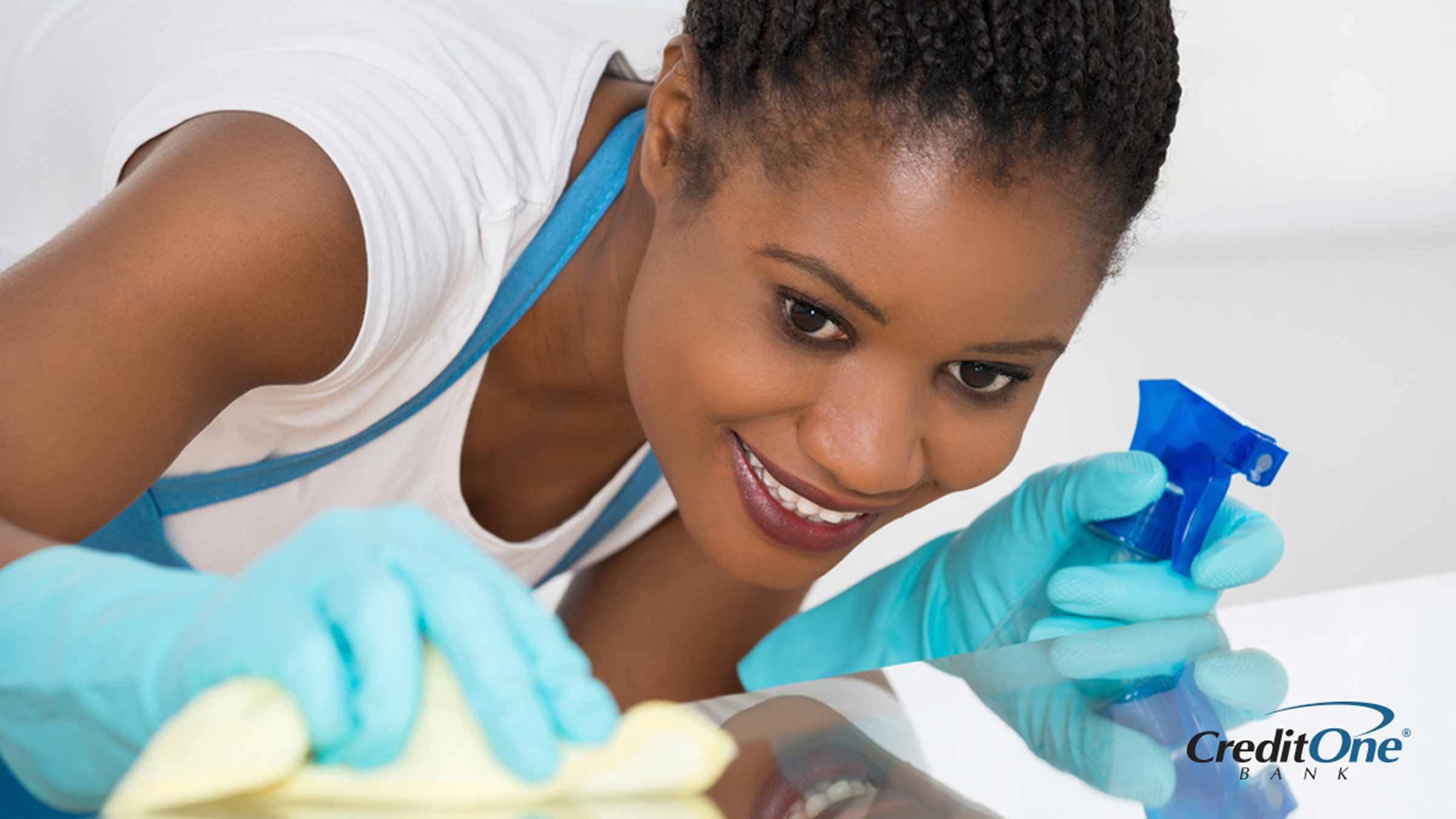 A woman spring cleaning her home with cleaning spray and a cloth