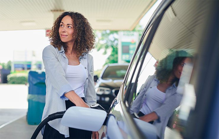 A woman pumping gas at a station